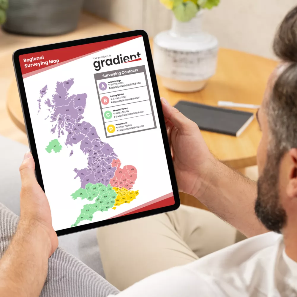 Man holds a tablet displaying a colourful map of the United Kingdom.