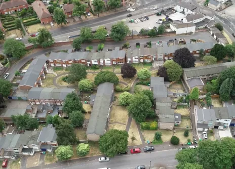 Aerial view of residential neighbourhood with trees and roads.
